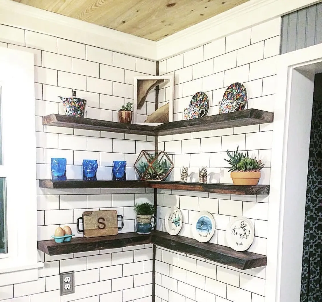 Black walnut floating shelves against subway tile with a cypress ceiling