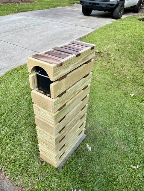 Modern mailbox in yellow pine slats with black walnut accents